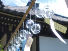 a bunch of bubbles hanging from a wooden pole in front of a building with a sky background