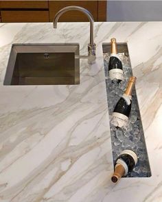 two bottles of wine sitting on top of a marble counter