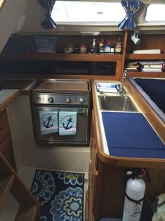 the inside of a sailboat with an oven and sink