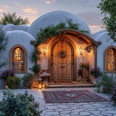 the entrance to a house with an arched door and potted plants on either side