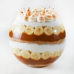 a bowl filled with bananas and other toppings sitting on top of a white table