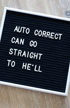 a sign that says auto correct can go straight to hell on a wooden table top