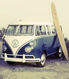 an old vw bus with a surfboard leaning against it