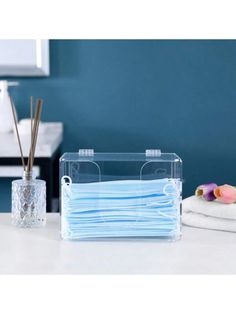 a blue face mask sitting on top of a counter next to a stack of white towels