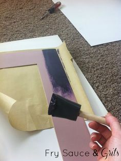 a person is painting an image on a piece of paper with a paintbrush in their hand