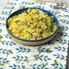 a blue bowl filled with food on top of a white and blue table cloth covered in leaves