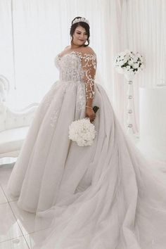 a woman in a white wedding dress standing next to a chair with flowers on it