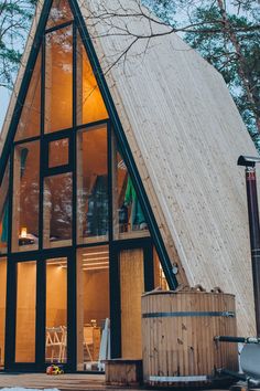 a small cabin with a hot tub in front of it and snow on the ground