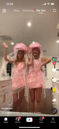 two women in pink dresses and hats standing next to each other