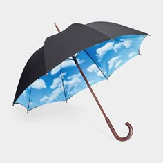 an umbrella with clouds on it is shown in this image, the blue sky has white clouds