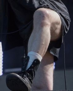 the legs and feet of a man with no shoes on performing at a music festival