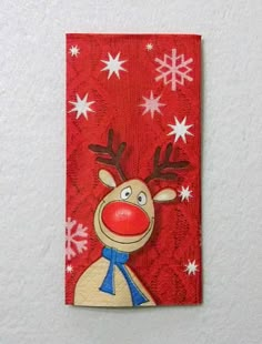 a red and white christmas card with a reindeer on it's head, surrounded by snowflakes