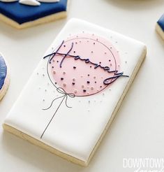 cookies decorated with icing and sprinkles are arranged on a white table