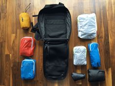 the contents of a backpack laid out on a wooden floor