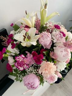 a vase filled with lots of pink and white flowers