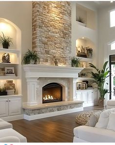 a living room with white furniture and a fireplace