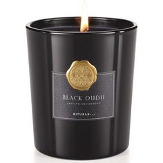 black oudh candle with a gold emblem on the front and bottom, in a glass container