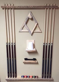 pool cues and cues hang on the wall above a rack with other pool items