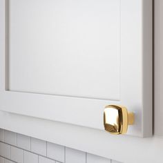 a close up of a door handle on a white cabinet