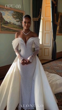 a woman in a white dress posing for the camera with her hands on her hips