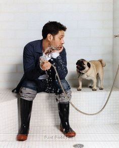 a man sitting on the ground with a dog in front of him and water coming out of his mouth