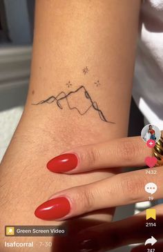 a woman's hand with a small tattoo on it