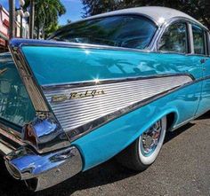 an old blue car is parked on the street