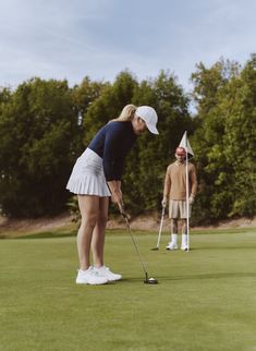 two people are playing golf on the green