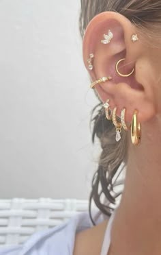 a woman wearing three different types of ear piercings on her left side, and one with