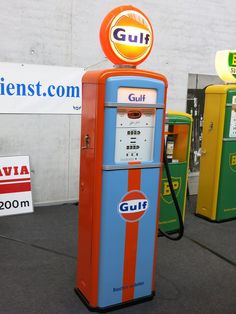 an old fashioned gas pump sitting in front of a sign that says gulf on it