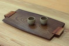 two cups sitting on top of a wooden tray