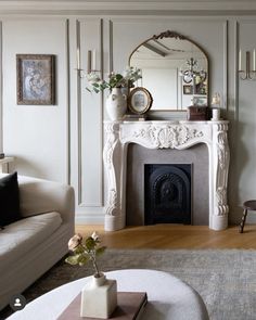 a living room filled with furniture and a fire place in front of a white fireplace