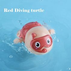 a red diving turtle in the water with goggles on it's head and eyes