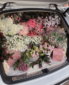 the trunk of a car is filled with flowers