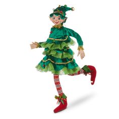 a doll dressed in green and red is flying through the air with her legs spread out