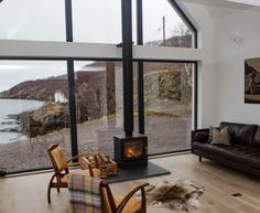 a living room filled with furniture and a fire place next to a large glass window