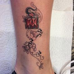 a woman's foot with a tattoo design on the side of her leg that has an image of a red diamond in it