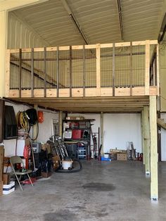 a garage filled with lots of tools and equipment under a wooden staircase above the garage