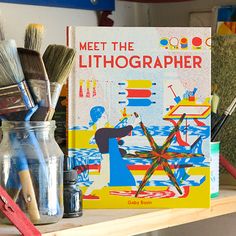 books and brushes are sitting on a shelf next to each other in front of a book