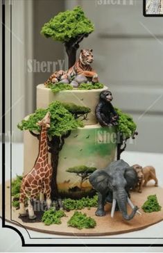 a three tiered cake decorated with animals and trees