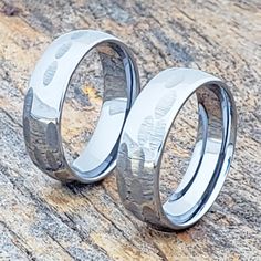 two wedding rings sitting on top of a wooden table