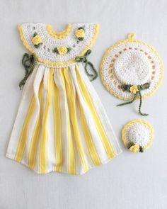 a baby's yellow and white dress with matching bib, hat and booties