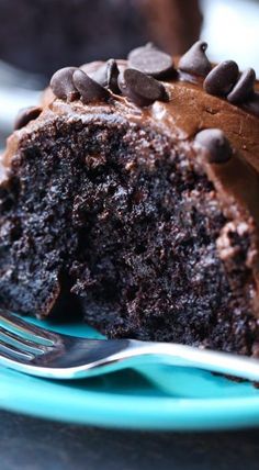 a piece of chocolate cake on a blue plate with a bite taken out of it