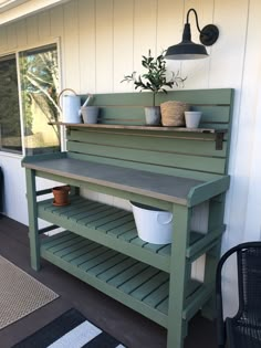 a potted plant sitting on top of a green bench next to a window and rug