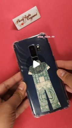 a person holding up a phone case with money on it