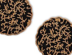 two decorative black and gold coasters on a white background, each with an intricate design