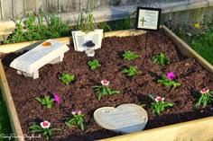 a wooden box filled with dirt and flowers next to a plaque that says, i love you