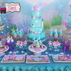 a table topped with cakes and desserts covered in blue frosted cake icing