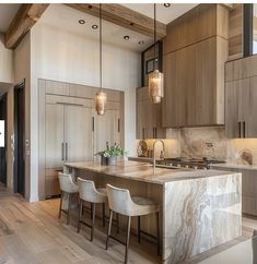 a large kitchen with marble counter tops and wooden cabinets in the center, along with white chairs