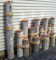 several wooden poles with ropes tied around them on the side of a house next to a building